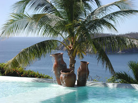 Pool, jars and palm tree overlooking beautiful bay and Pacific Ocean.