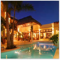 Home exterior with pool at night.